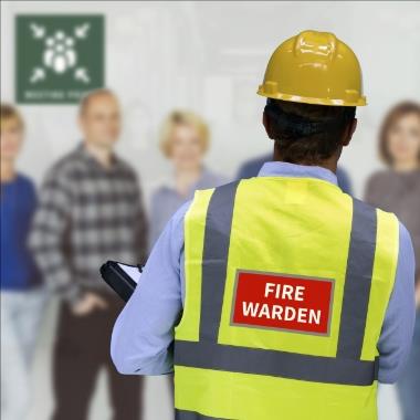 Fire warden in safety vest giving fire safety training to group.