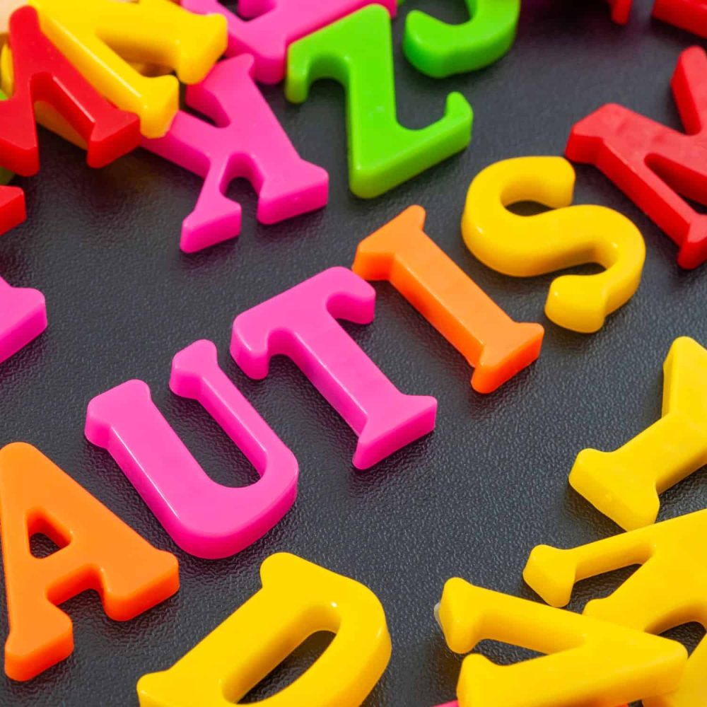 Colorful plastic alphabet letters on black background for early learning.