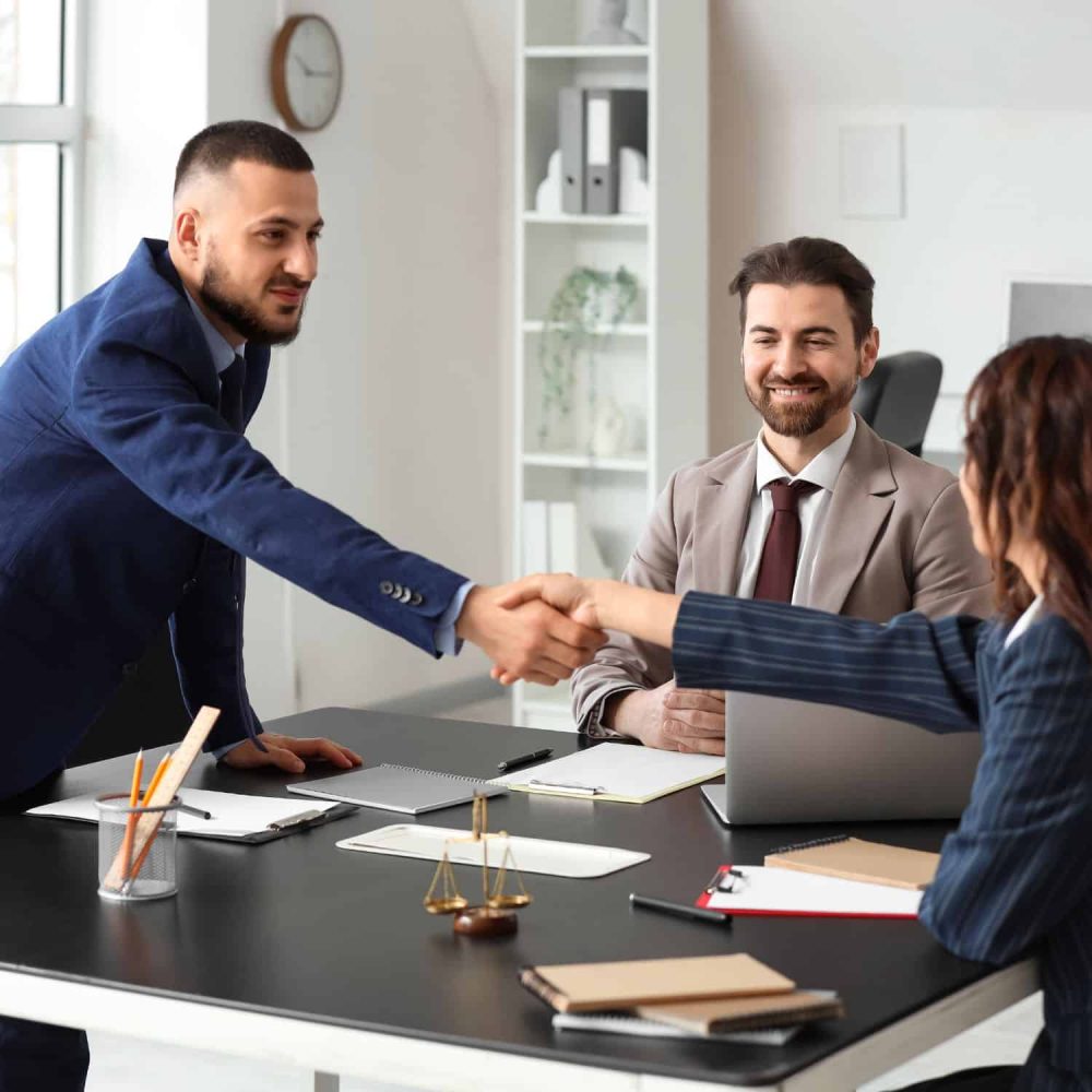Business professionals shaking hands in a workplace meeting.