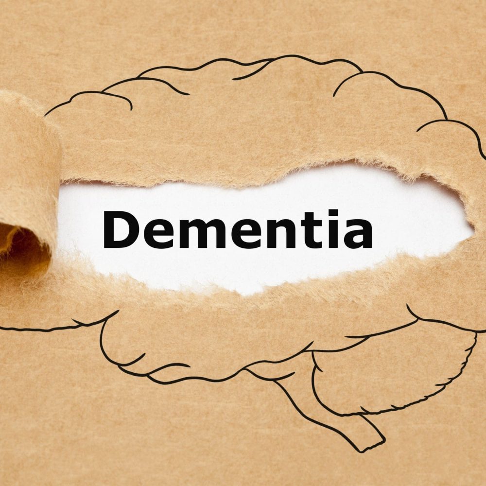 Dementia awareness concept with torn paper and brain outline.