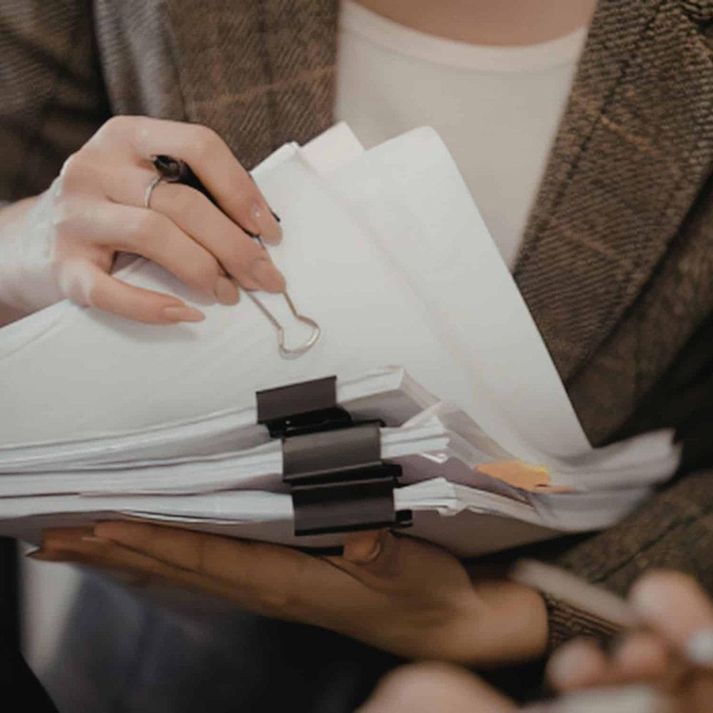 Person holding a clipboard with documents for care training.