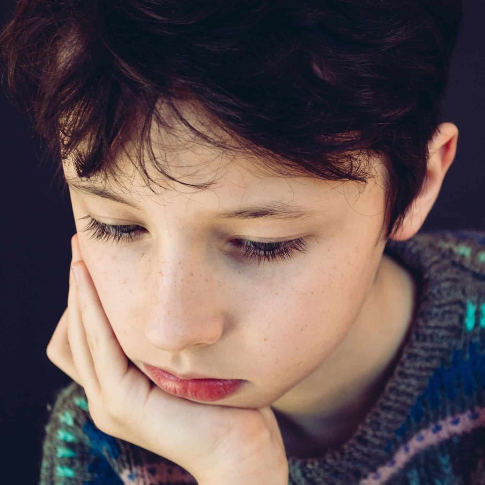 Young boy with thoughtful expression, representing children's mental health awareness.