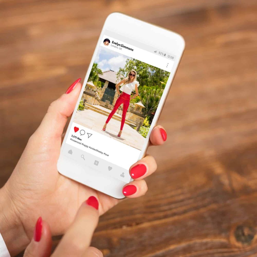 Woman holding smartphone displaying Instagram post for business training.
