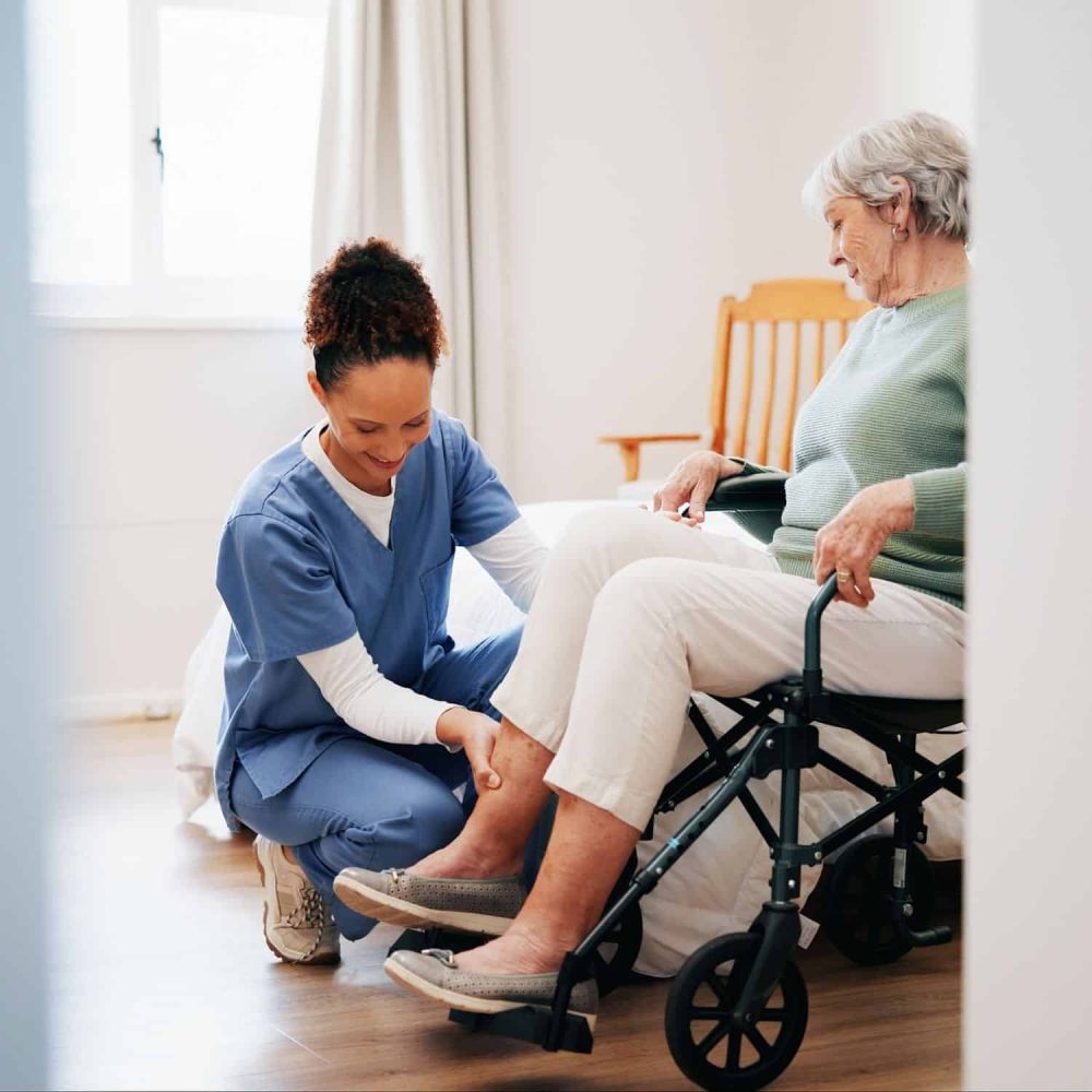 Caregiver assisting elderly woman with mobility training in home setting.
