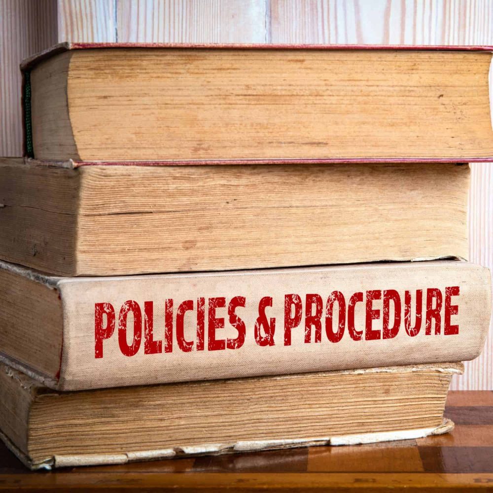 Stack of books with 'Policies & Procedure' on the spine.