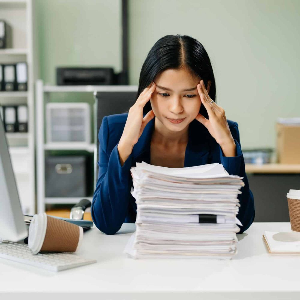 Overwhelmed woman with stress at work, managing workload.
