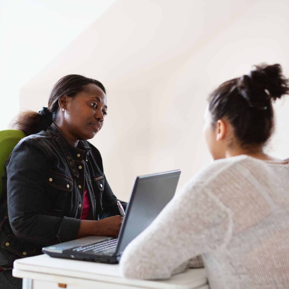 Two women in a professional setting discussing mental health supervision.