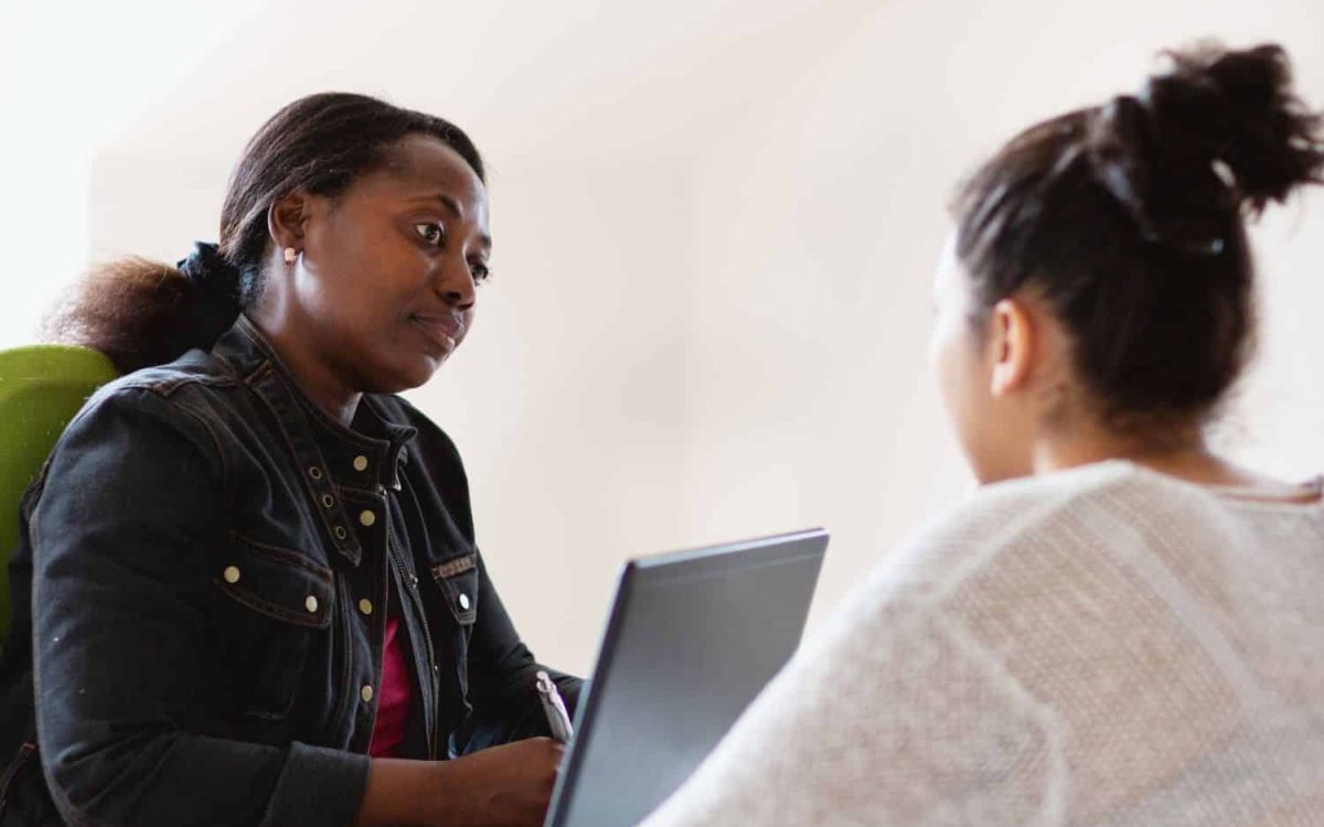 Two women in a professional setting discussing mental health supervision.