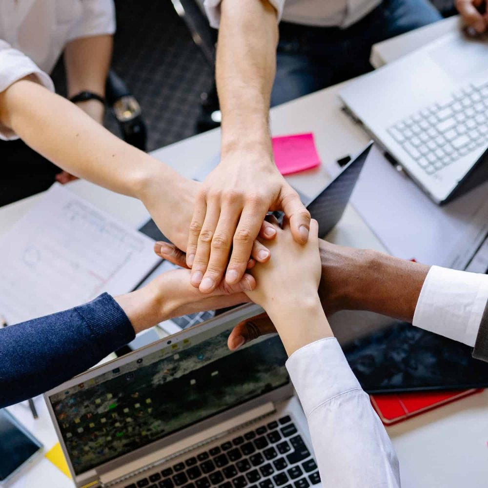 Team members stacking hands for teamwork and leadership.