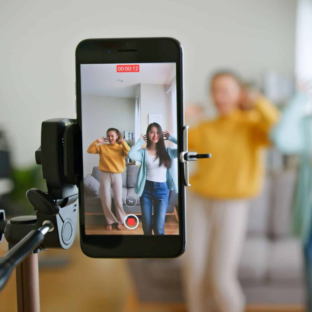 Recording TikTok video with two women in a living room.