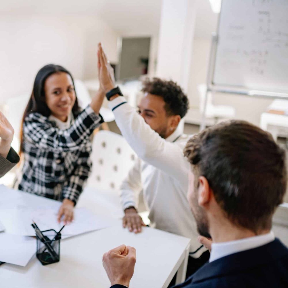 Team high-fiving during employee relations training session.